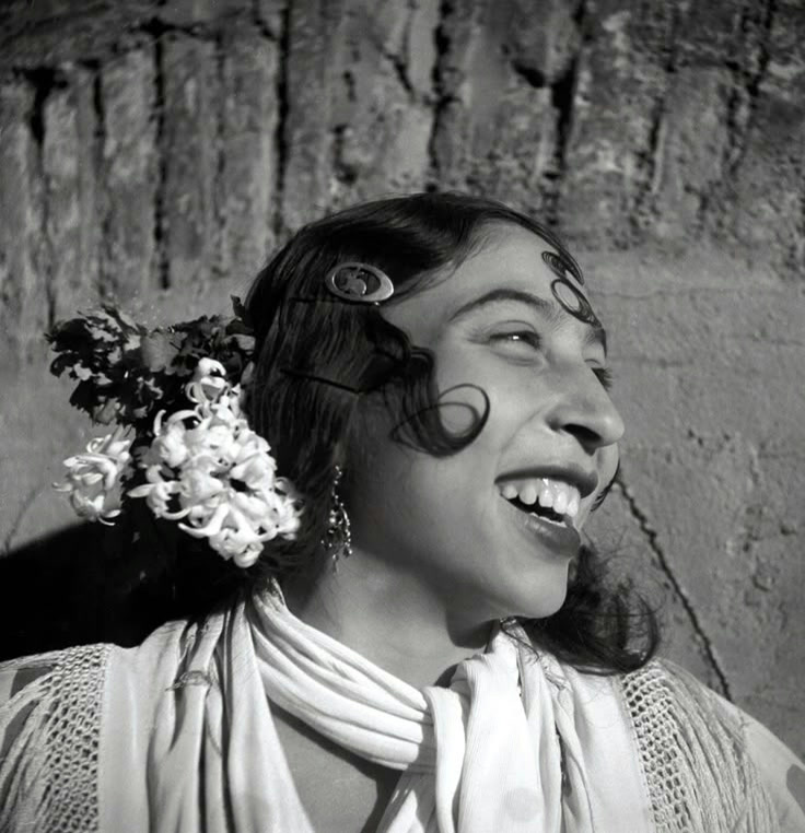 A woman laughing with flowers in her hair, from Cristina Garcia Rodero