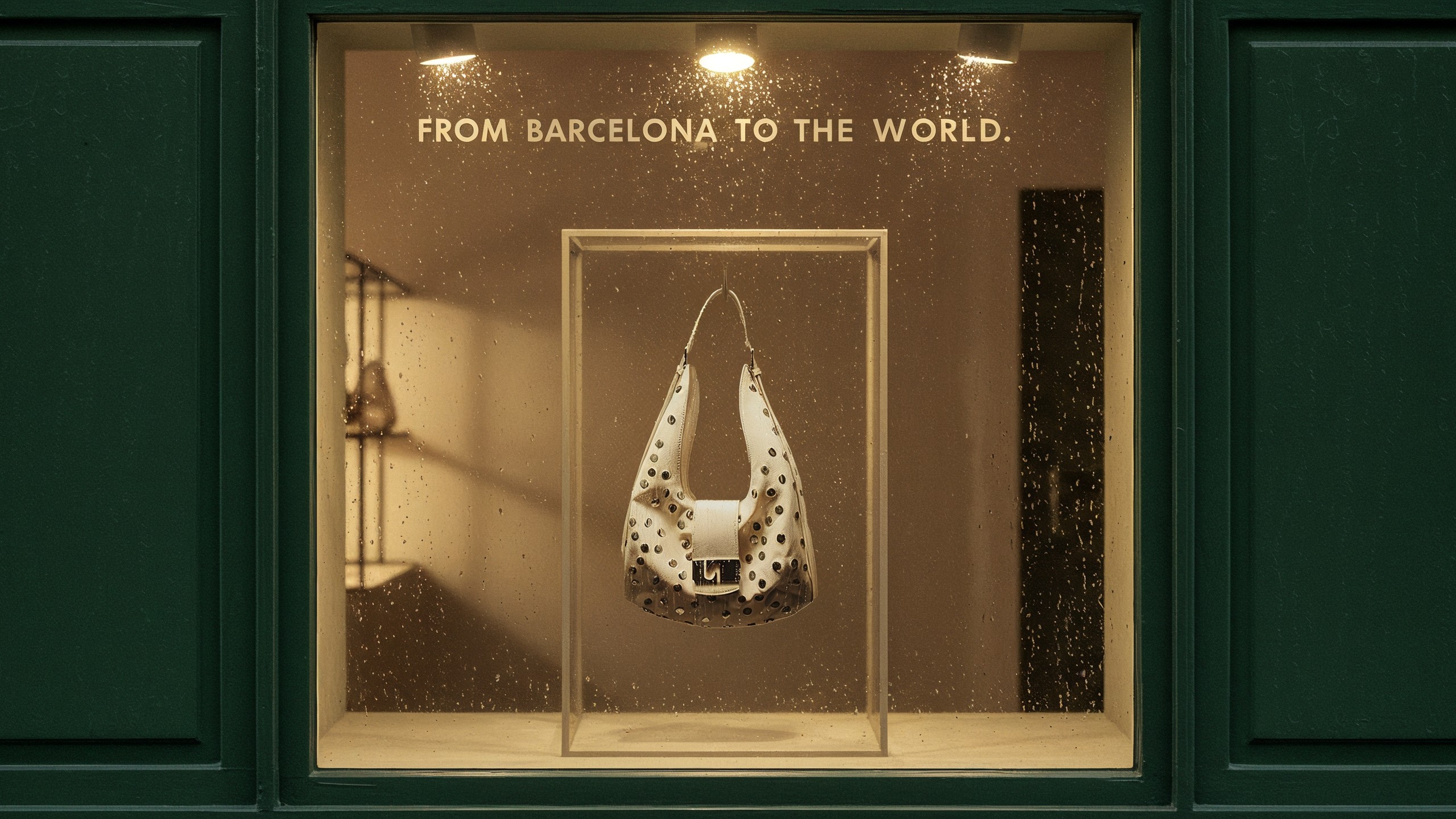 The VIXEN bag lit on a plinth in a shop vitrine, under the words FROM BARCELONA TO THE WORLD