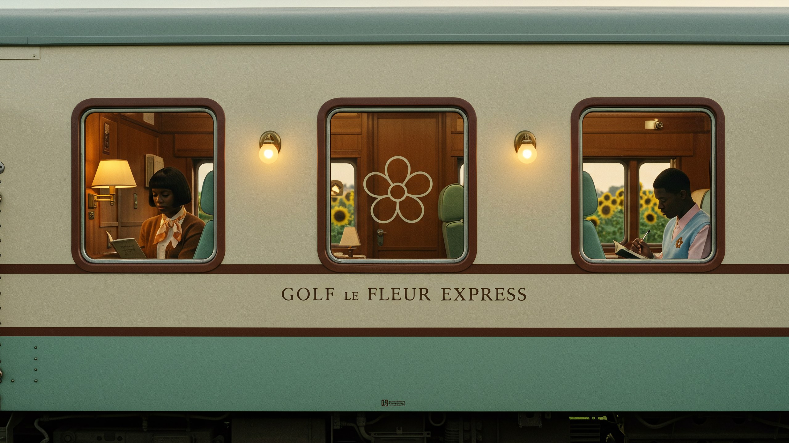 The side of a mint and cream carriage lettered GOLF LE FLEUR EXPRESS, three lit windows with passengers inside