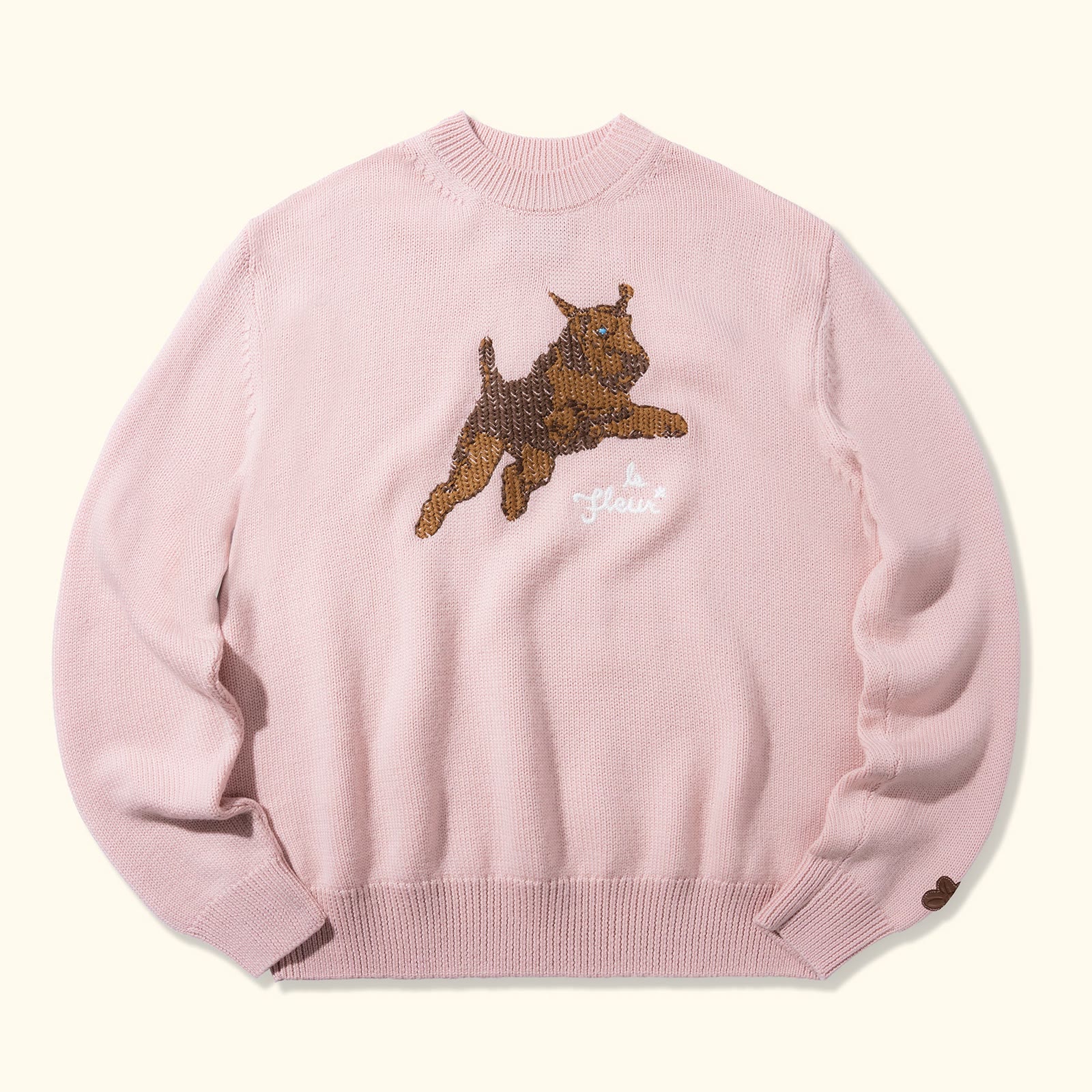 The pink Golf le Fleur crewneck with the Airedale terrier on the chest, photographed on white