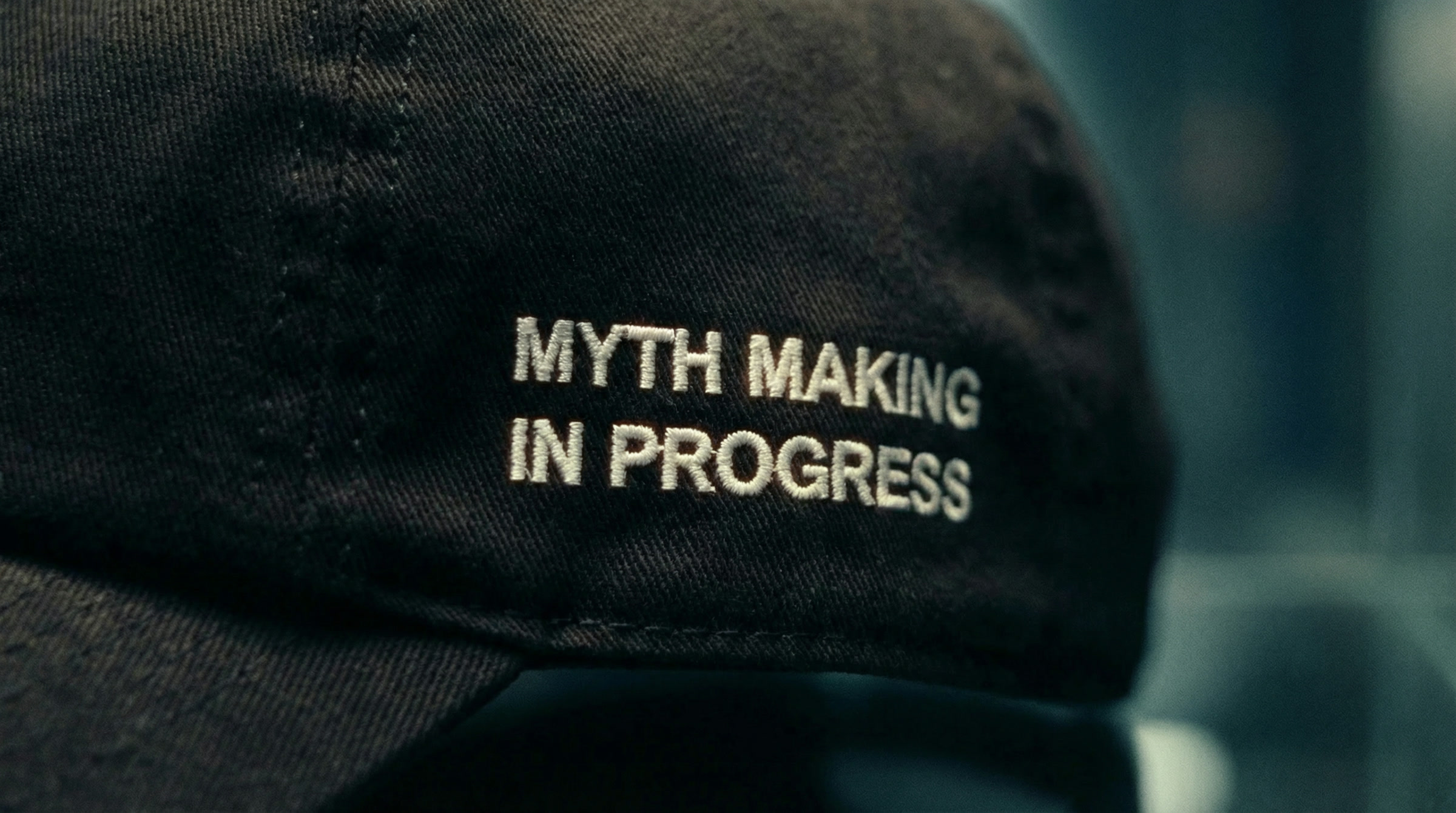 A macro of the embroidery reading MYTH MAKING IN PROGRESS